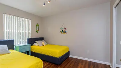 a bedroom with two beds with yellow sheets at Villas At Island Club Community, Pools, Jacuzzi And More! in Kissimmee