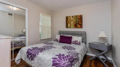 a bedroom with a purple and white bed and a mirror at Villas At Island Club Community, Pools, Jacuzzi And More! in Kissimmee