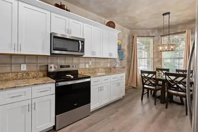 a kitchen with white cabinets and a black stove top oven at Free Arcade! All Rooms Themed! South Facing Pool! in Orlando