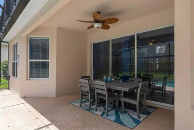 a dining room with a table and a ceiling fan at Free Arcade! All Rooms Themed! South Facing Pool! in Orlando