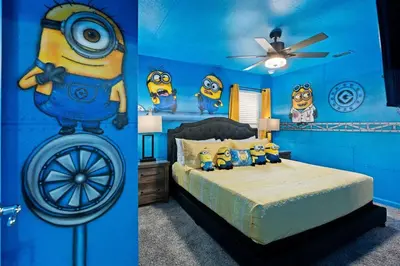 a bedroom with a blue wall with a bed with minions on it at Free Arcade! All Rooms Themed! South Facing Pool! in Orlando