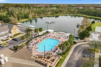 an aerial view of a swimming pool and a lake at 4 Bedroom 3 Bathroom Villas At SevenDwarfs 27-108 in Kissimmee