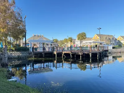a dock with houses on the side of a body of water at 4 Bedroom 3 Bathroom Villas At SevenDwarfs 27-108 in Kissimmee