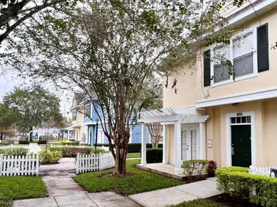 a house with a tree in the front yard at Cute and Cozy 4Bed Townhome Venetian Bay-2200SCD in Kissimmee