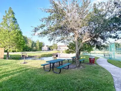 a park with three picnic tables and a tree at Cute and Cozy 4Bed Townhome Venetian Bay-2200SCD in Kissimmee