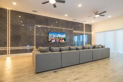 a living room with a couch and a tv on a wall at BRAND NEW 15Bed Home wprivate Pool 5824 in Orlando