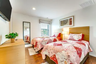 a bedroom with two beds and a mirror at 4 Mi to Disney World Townhome with Hot Tub and Lanai! in Kissimmee
