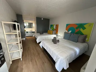 a room with two beds and a book shelf at Apartamento Perto Disney in Kissimmee