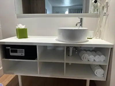 a bathroom counter with a sink and a microwave at Apartamento Perto Disney in Kissimmee