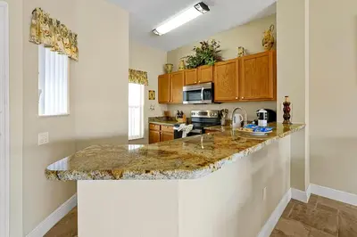 a kitchen with a granite counter top in a room at Lakefront Villa in Terra Verde:Pool & Resort Amenities in Kissimmee