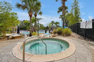 a swimming pool with a hot tub with palm trees at Lakefront Villa in Terra Verde:Pool & Resort Amenities in Kissimmee