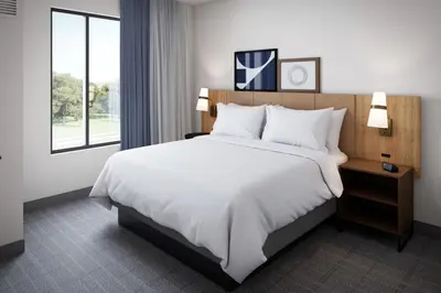 a hotel room with a large bed and a window at Staybridge Suites Clermont Southeast by IHG in Clermont