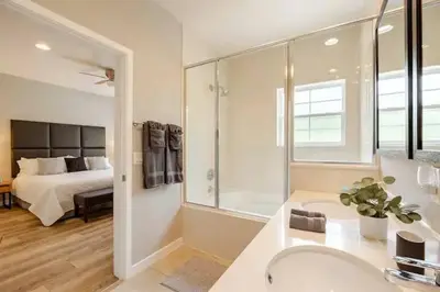 a bathroom with a sink and a bedroom with a bed at Corvette Getaway - 2 beds - jacuzzi - Forest view in Orlando