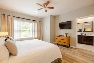 a bedroom with a white bed and a ceiling fan at Corvette Getaway - 2 beds - jacuzzi - Forest view in Orlando
