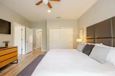 a bedroom with a large white bed with a ceiling fan at Corvette Getaway - 2 beds - jacuzzi - Forest view in Orlando