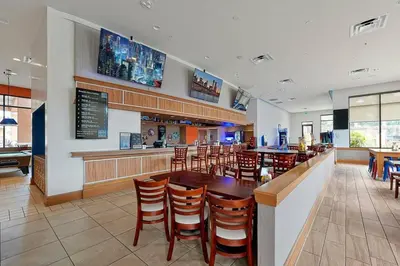 a restaurant with a bar and tables and chairs at Corvette Getaway - 2 beds - jacuzzi - Forest view in Orlando