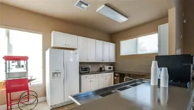a kitchen with white cabinets and a white refrigerator at Disney Area Retreat 6BR4BA with Private Pool Theater Game Room Bella Vida Resort BV4509 in Kissimmee