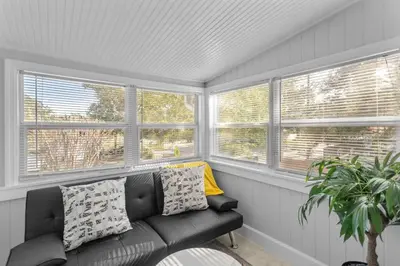 a living room with a couch and three windows at King bd Charming 2-Storey Cottage w PrivateYard in Orlando
