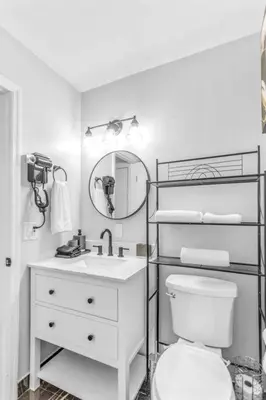a white bathroom with a toilet and a sink at King bd Charming 2-Storey Cottage w PrivateYard in Orlando