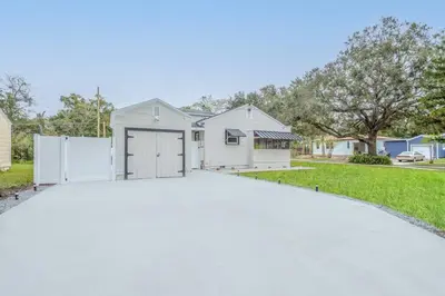 a white house with a garage in a driveway at King bd Charming 2-Storey Cottage w PrivateYard in Orlando
