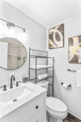 a bathroom with a sink and a toilet and a mirror at King bd Charming 2-Storey Cottage w PrivateYard in Orlando