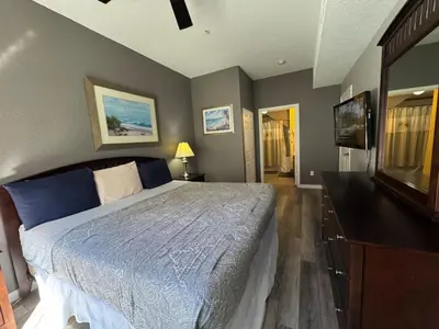 a bedroom with a bed and a flat screen tv at 4 Bedroom 3 Bathroom Villas At SevenDwarfs 17-101 in Kissimmee