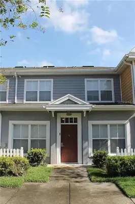 a gray house with a red door and a driveway at 3 Bedroom 2 Bathroom Villas At SevenDwarfs 8-103 in Kissimmee