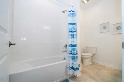 a white bathroom with a tub and a toilet at 3191#402 Family Fun 3BR Themed Apt Near Disney in Kissimmee