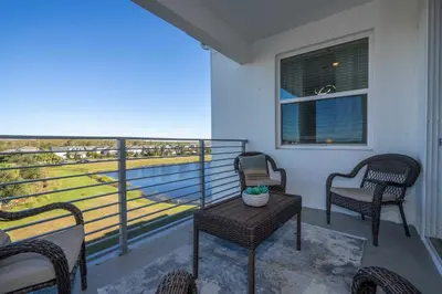 a balcony with chairs and a table and a view of the ocean at 3191#402 Family Fun 3BR Themed Apt Near Disney in Kissimmee