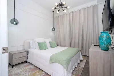 a white bedroom with a bed and a blue vase at 3191#402 Family Fun 3BR Themed Apt Near Disney in Kissimmee