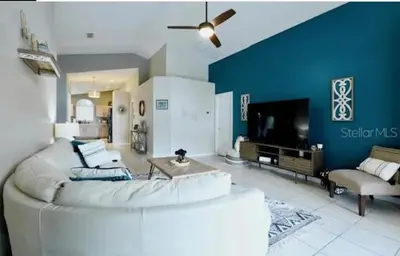 a living room with a white couch and a blue wall at Enchanted Disney Vacation Villa in Kissimmee