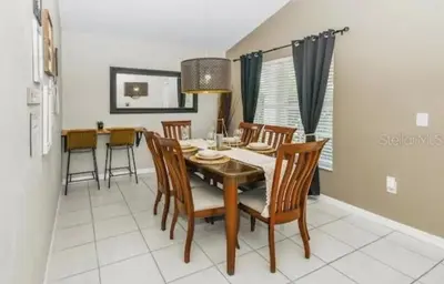 a dining room with a table and chairs at Enchanted Disney Vacation Villa in Kissimmee
