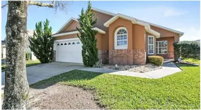 a house with a tree in front of it at Enchanted Disney Vacation Villa in Kissimmee