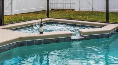 a bottle of wine in a swimming pool at Enchanted Disney Vacation Villa in Kissimmee