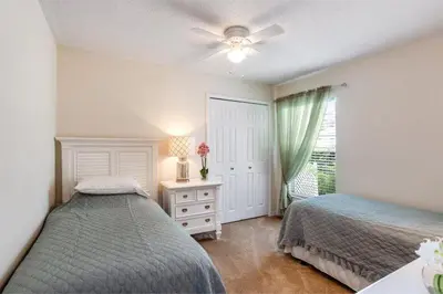 a bedroom with two beds next to a window at Beautiful 4 Bed Villa With Southwest Facing Pool in Orlando