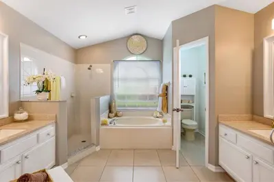 a large bathroom with a tub and a toilet at Beautiful 4 Bed Villa With Southwest Facing Pool in Orlando