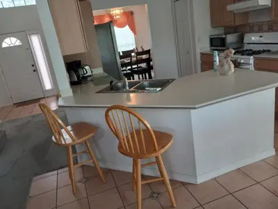 a kitchen with a island with two chairs and a counter at Fabulous 4 Bed South Facing Lake View Near Disney in Orlando