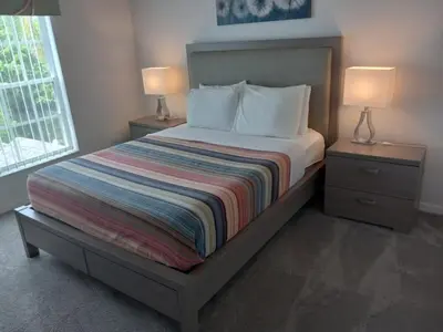 a bedroom with a bed with two night stands and two lamps at Fabulous 4 Bed South Facing Lake View Near Disney in Orlando
