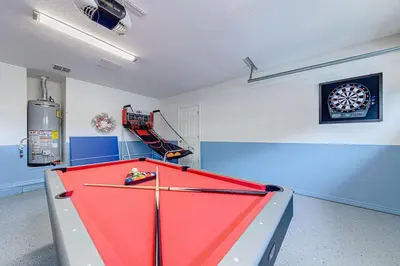 a pool table in a room with a dartboard on the wall at Spacious 4 Bed South Facing Pool Villa Near Disney in Orlando
