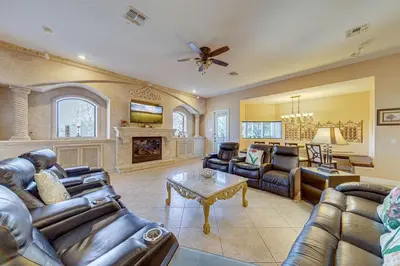 a living room with leather furniture and a fireplace at Spacious 7 Bedroom Home Close To Disney in Orlando