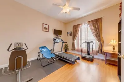 a living room with a gym with a treadmill and a fan at Spacious 7 Bedroom Home Close To Disney in Orlando
