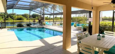 a swimming pool in a house with a table and chairs at Hidden Waterfront Oasis - 18 Minutes To The Disney in Orlando