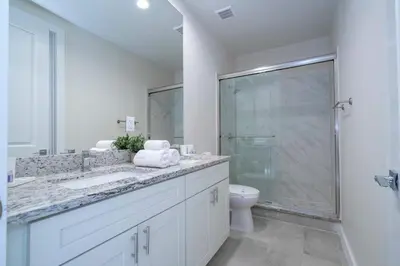 a white bathroom with a shower and a toilet at Luxury 3BR home with Mario Bros Room Near Disney in Orlando