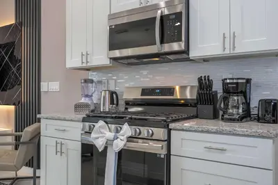 a kitchen with a stove and a microwave at Luxury 3BR home with Mario Bros Room Near Disney in Orlando