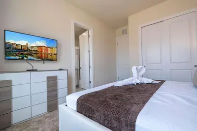 a bedroom with a bed and a tv on a wall at Luxury 3BR home with Mario Bros Room Near Disney in Orlando