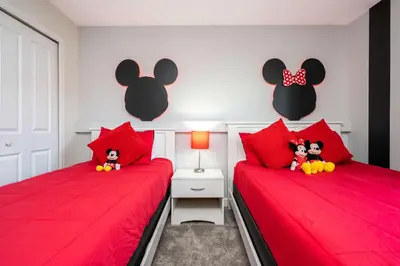 two beds with red pillows with stuffed mice on them at Storey Lake Home Mickey & Minions Beds Sleeps 12 in Kissimmee