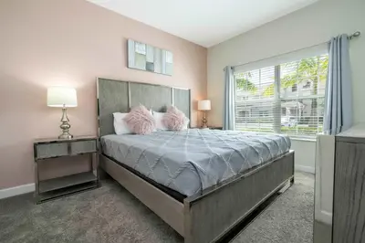 a bedroom with a large bed and a window at Storey Lake Home Mickey & Minions Beds Sleeps 12 in Kissimmee