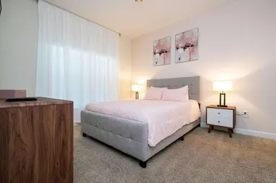 a bedroom with a bed and a dresser with two lamps at Great Home Mickey & Harry Potter Beds Top Spot in Kissimmee