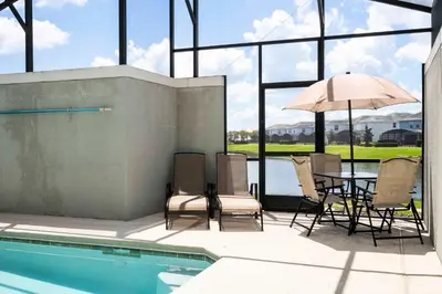 a patio with a table and chairs and an umbrella at Great Home Mickey & Harry Potter Beds Top Spot in Kissimmee