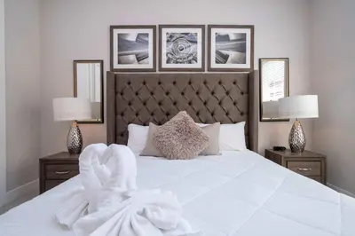 a bedroom with a white bed with two night stands at Modern Chic Home Mickey and Toy Story Rooms in Orlando